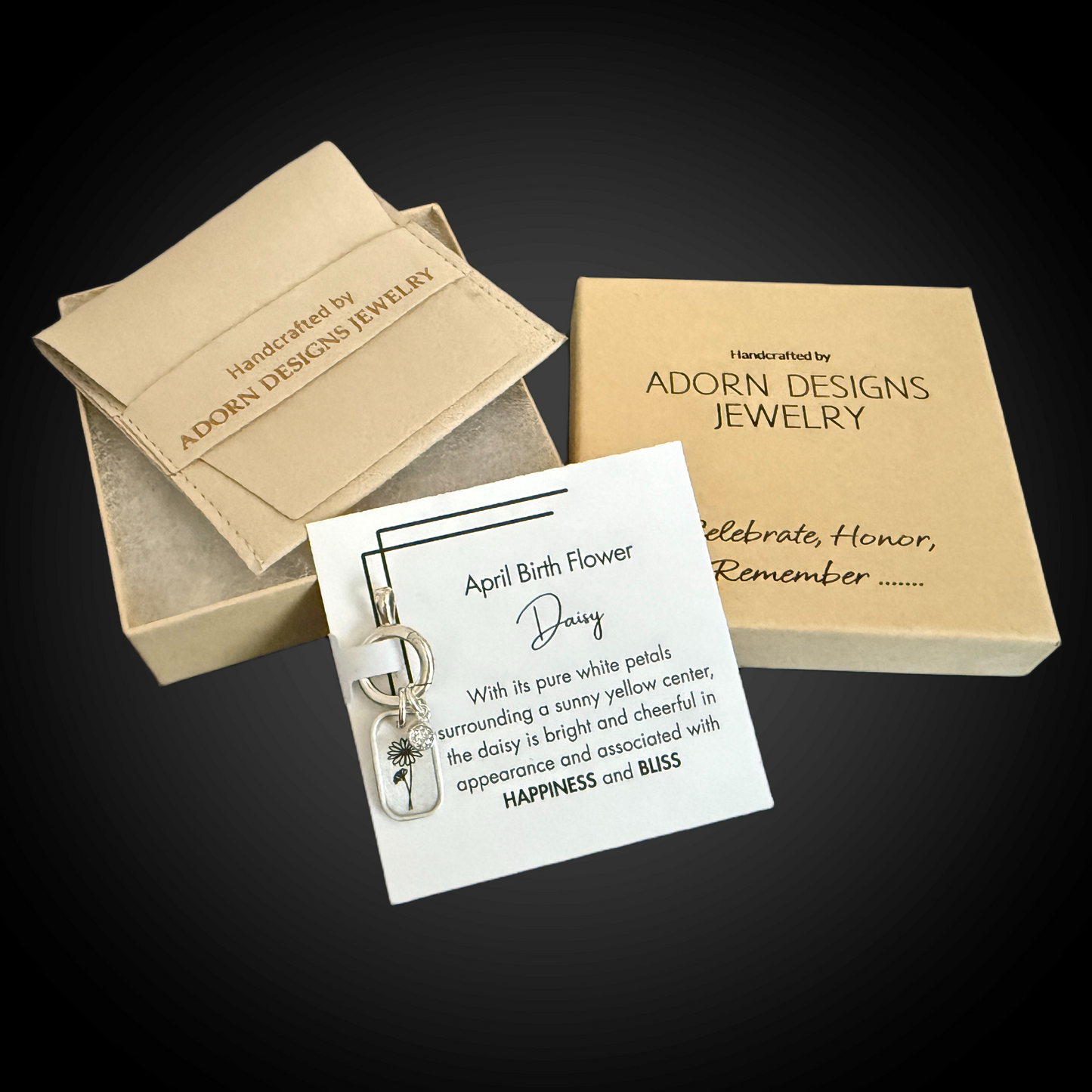 Jewelry box with a card featuring a daisy pendant and product description on a dark background.
