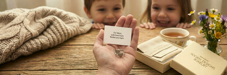 two children happy to give their mother a ring with both of their fingerprints