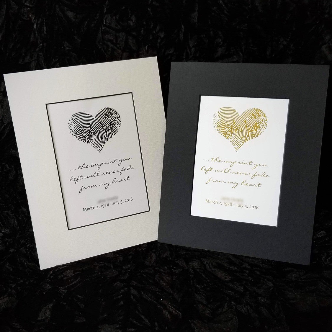 Two framed prints with fingerprint heart designs on a dark textured background