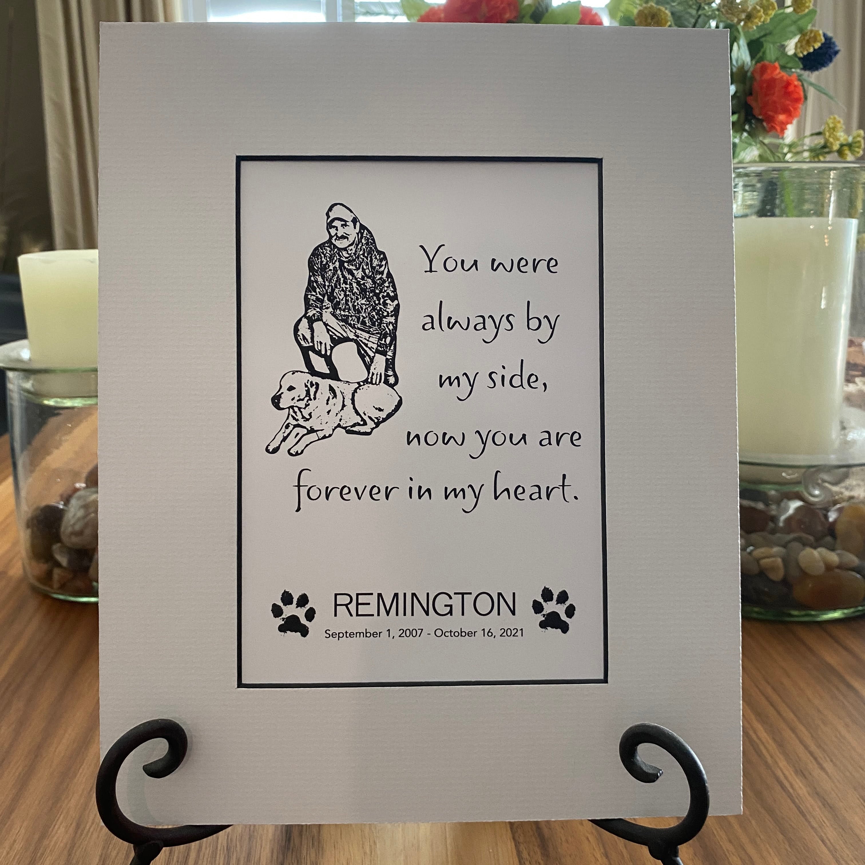 Memorial plaque for a pet named Remington with text and illustrations on a stand.