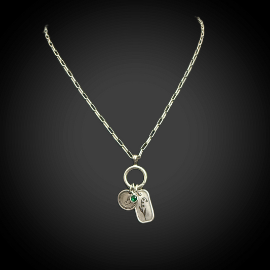 Close view of minimalist Lily of the Valley line engraving on 3/4 × 1/2 inch silver charm and paperclip necklace