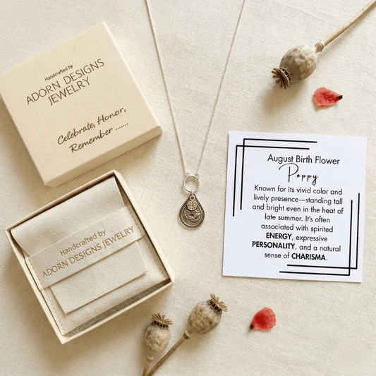 August poppy birth flower sterling silver necklace with peridot-green CZ stone, Adorn Designs gift box, pouch, and August poppy meaning card.