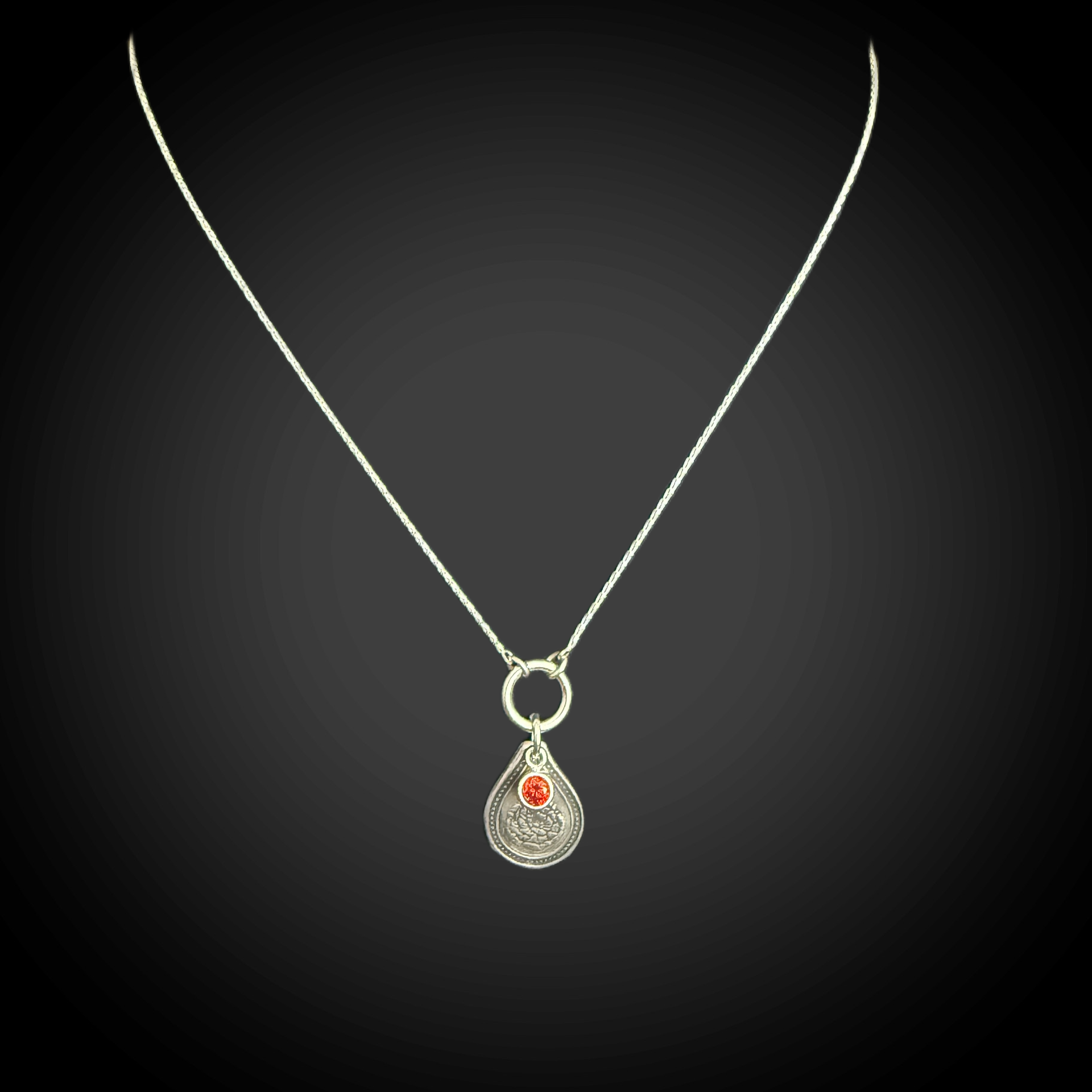 Sterling silver January birth flower necklace with carnation engraving and garnet-red CZ birthstone by Adorn Designs Jewelry.