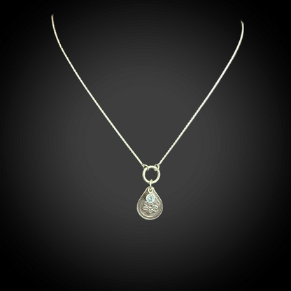 Sterling silver March birth flower necklace with daffodil engraving and aquamarine CZ stone by Adorn Designs Jewelry.