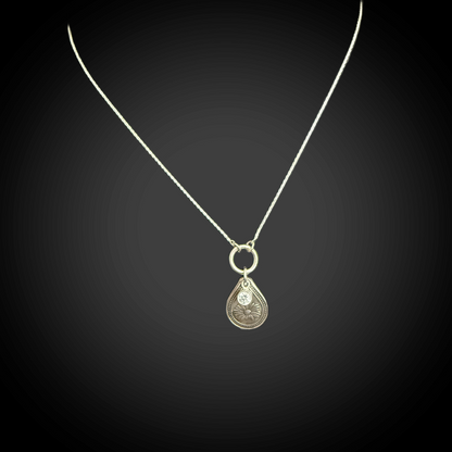 Sterling silver April birth flower necklace with daisy engraving and clear diamond-like CZ stone by Adorn Designs Jewelry.