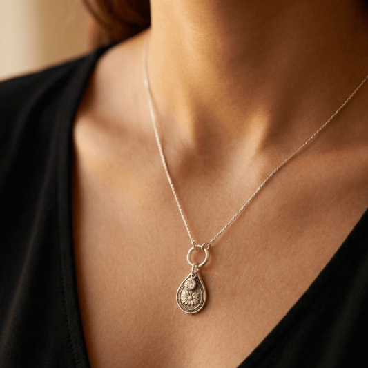 April daisy birth flower sterling silver necklace with clear diamond-like CZ stone shown on neckline for scale.