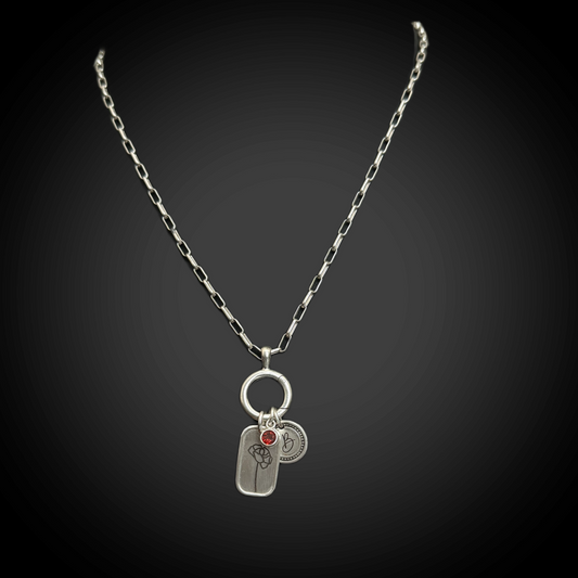Silver necklace with two charms on a black background