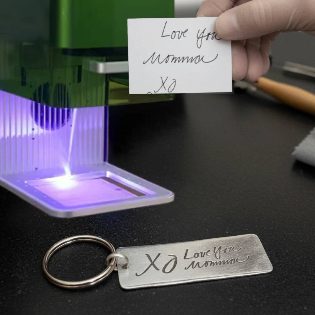 Hand holding a note with 'Love you Mommy XO' next to a engraved keychain in front of a UV light.