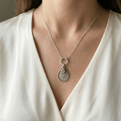 October marigold birth flower sterling silver necklace with pink tourmaline CZ stone shown on neckline for scale.