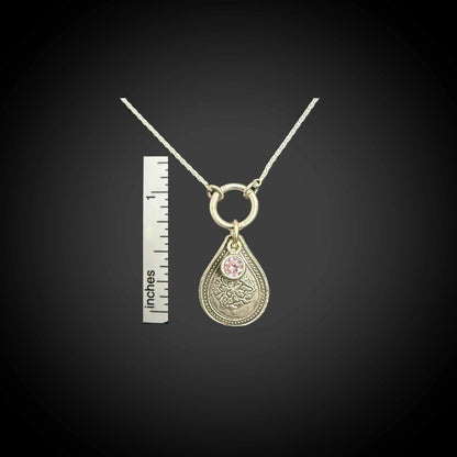 Size reference of October marigold birth flower sterling silver necklace with pink tourmaline CZ stone next to inch ruler.
