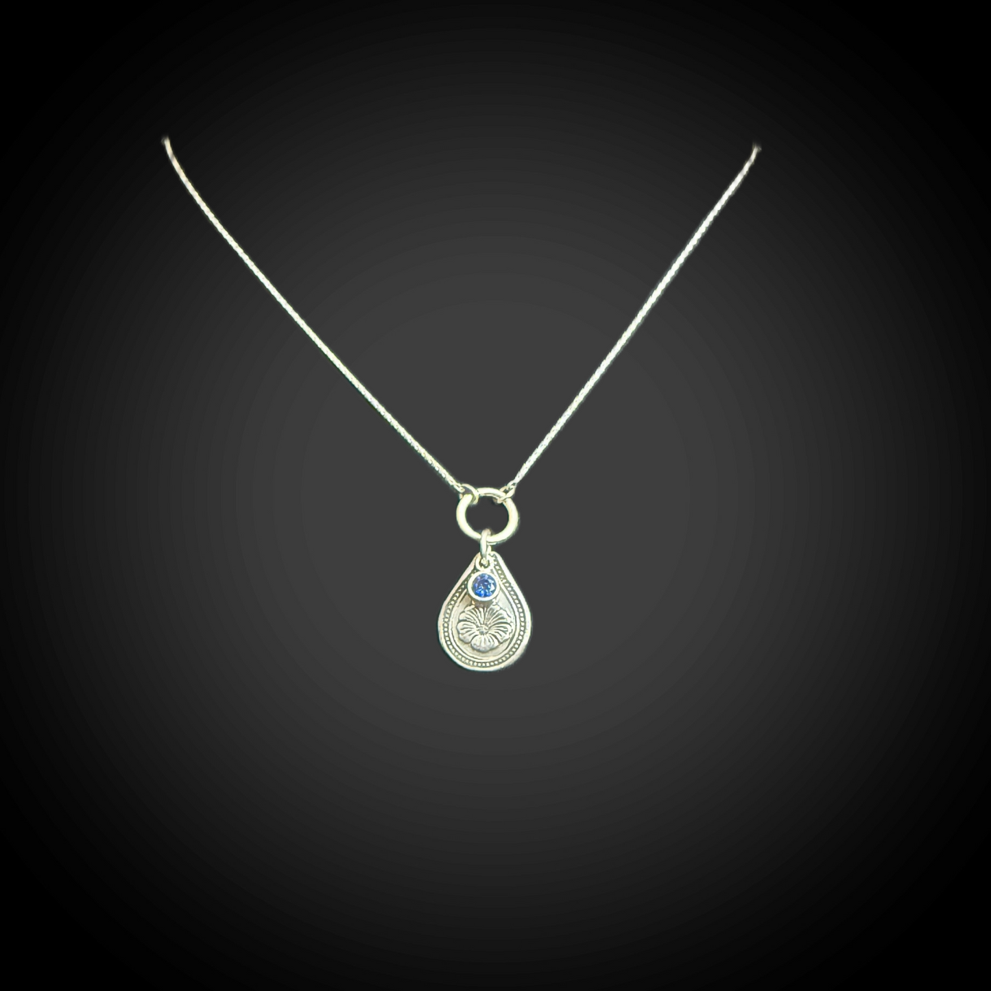 Sterling silver September birth flower necklace with morning glory engraving and sapphire-blue CZ stone by Adorn Designs Jewelry.