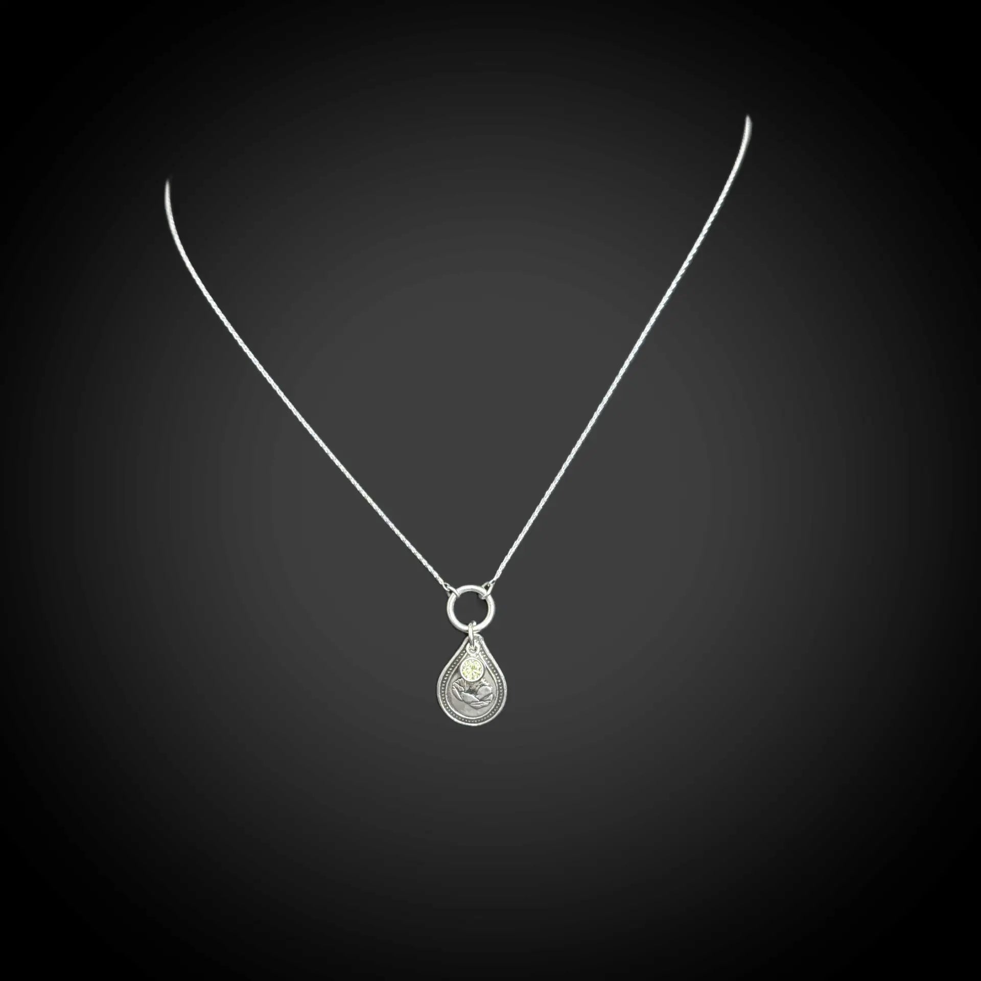 Sterling silver August birth flower necklace with poppy engraving and peridot-green CZ stone by Adorn Designs Jewelry.
