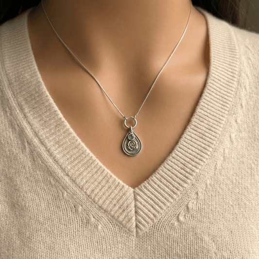 June rose birth flower sterling silver necklace with emerald-green CZ stone shown on neckline for scale.