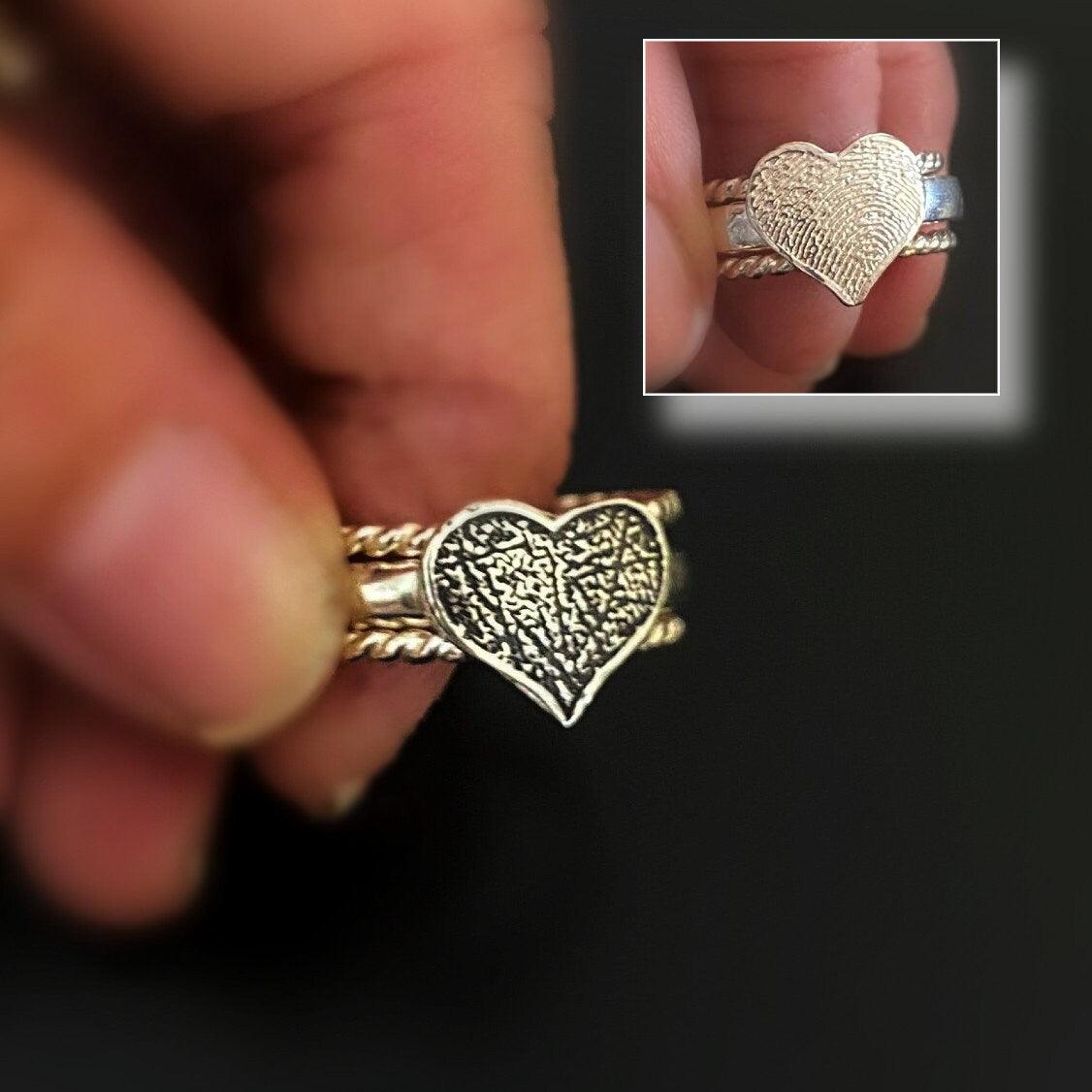 Angled shot of unisex fingerprint heart stacking ring—textured and polished mix